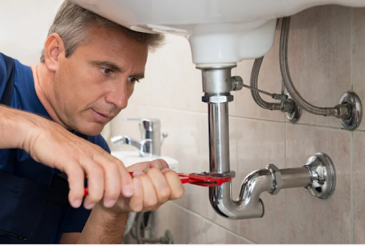 a man tightening faucet pipes
